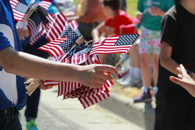 Handing out American flags at a parade embodies the spirit of community and patriotism on the 4th of July.